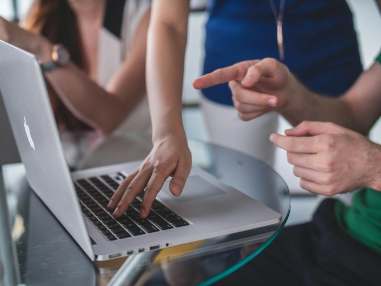 pay as you go Hands of two people interacting with a laptop during a discussion.