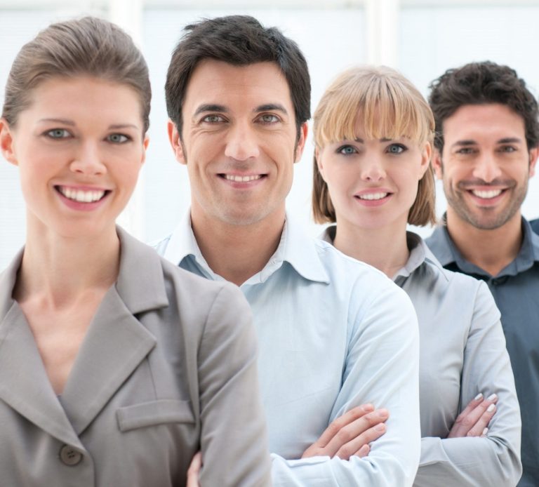 A diverse group of four smiling professionals standing in a line.